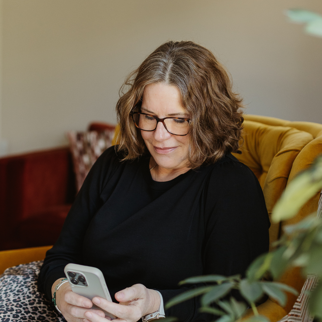 Founder of Good Wash Day reading customer hair towel reviews on her phone