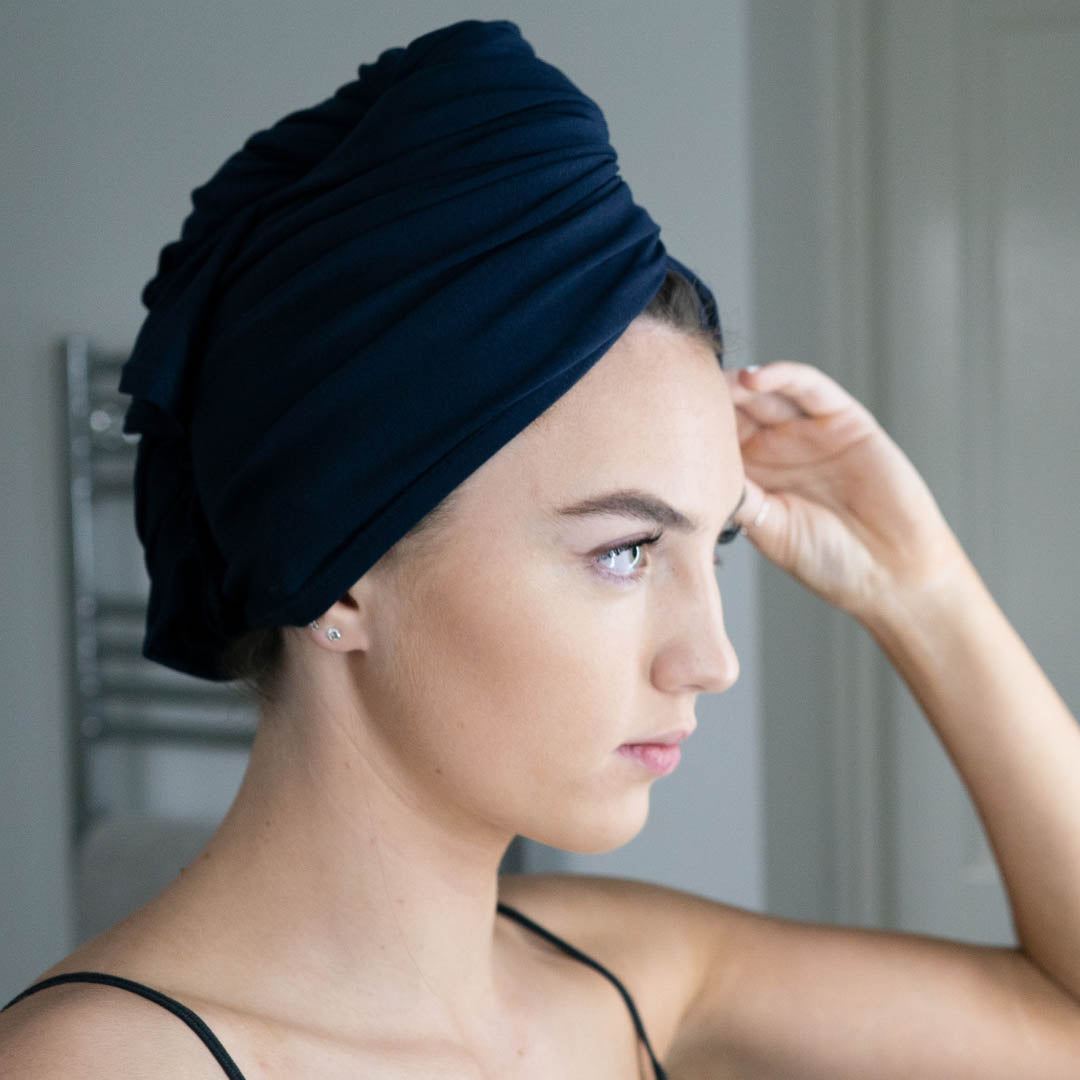 Woman in bathroom wearing navy blue organic jersey cotton hair towel wrap – Good Wash Day