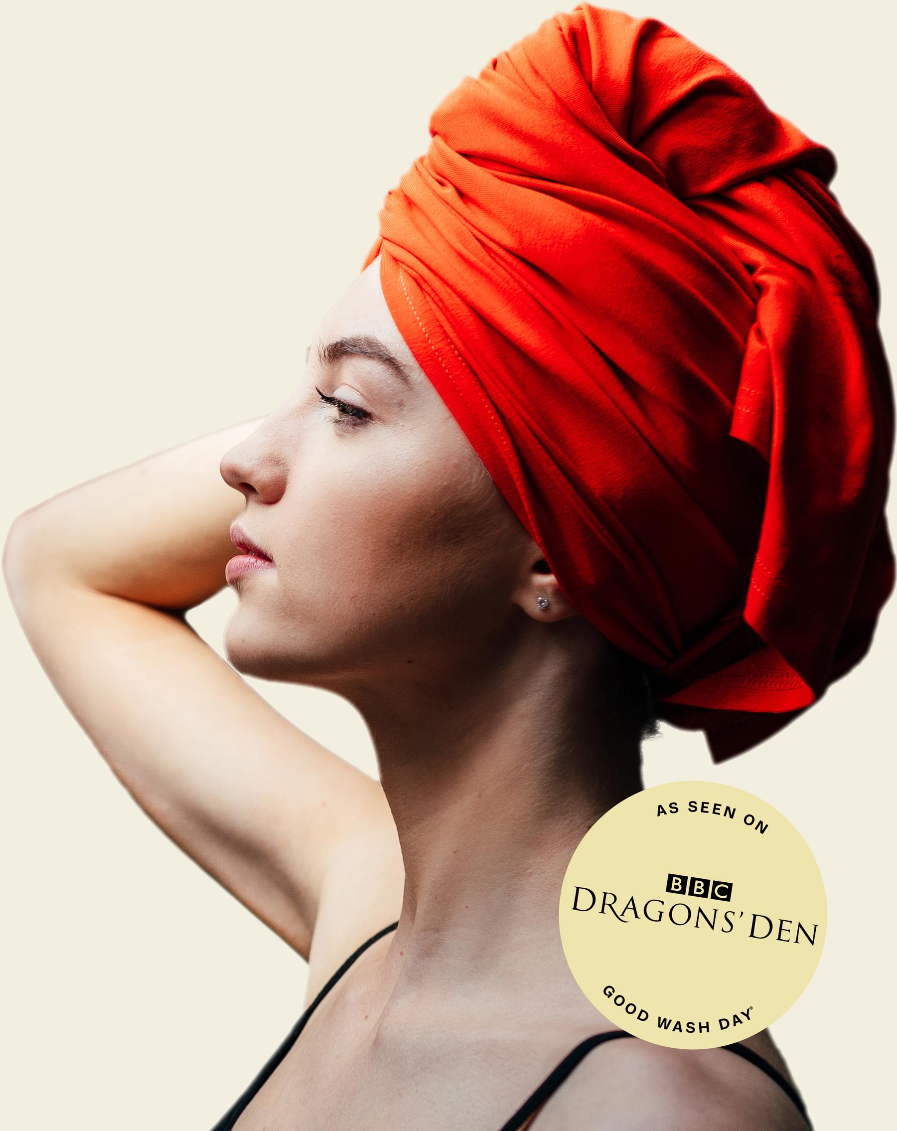 A woman in profile wearing a bright red-orange hair towel wrap against a warm off-white background. A circular badge reads 'AS SEEN ON BBC DRAGONS' DEN GOOD WASH DAY'.