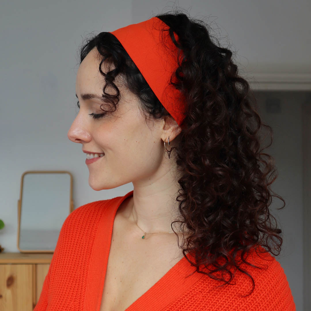 Woman with curly hair wearing orange organic jersey cotton headband – Good Wash Day