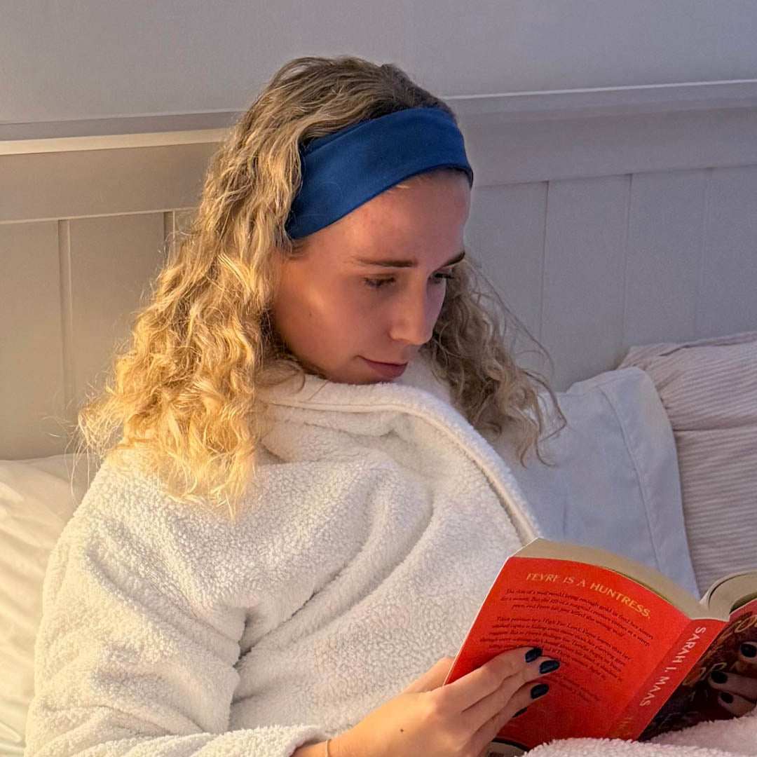 Woman with blonde hair wearing organic jersey cotton headband whilst reading in bed – Good Wash Day