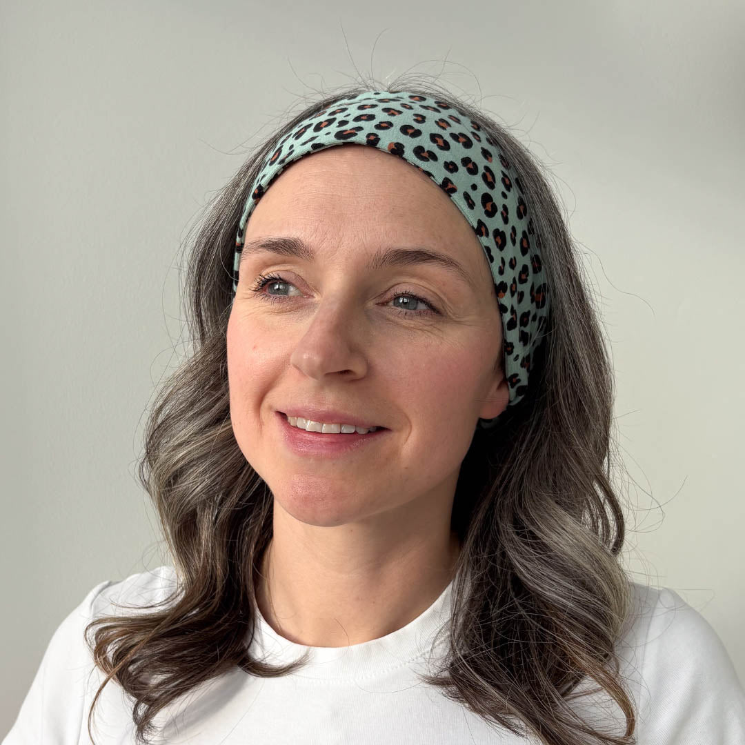 Woman with grey hair wearing green animal print organic jersey cotton headband – Good Wash Day