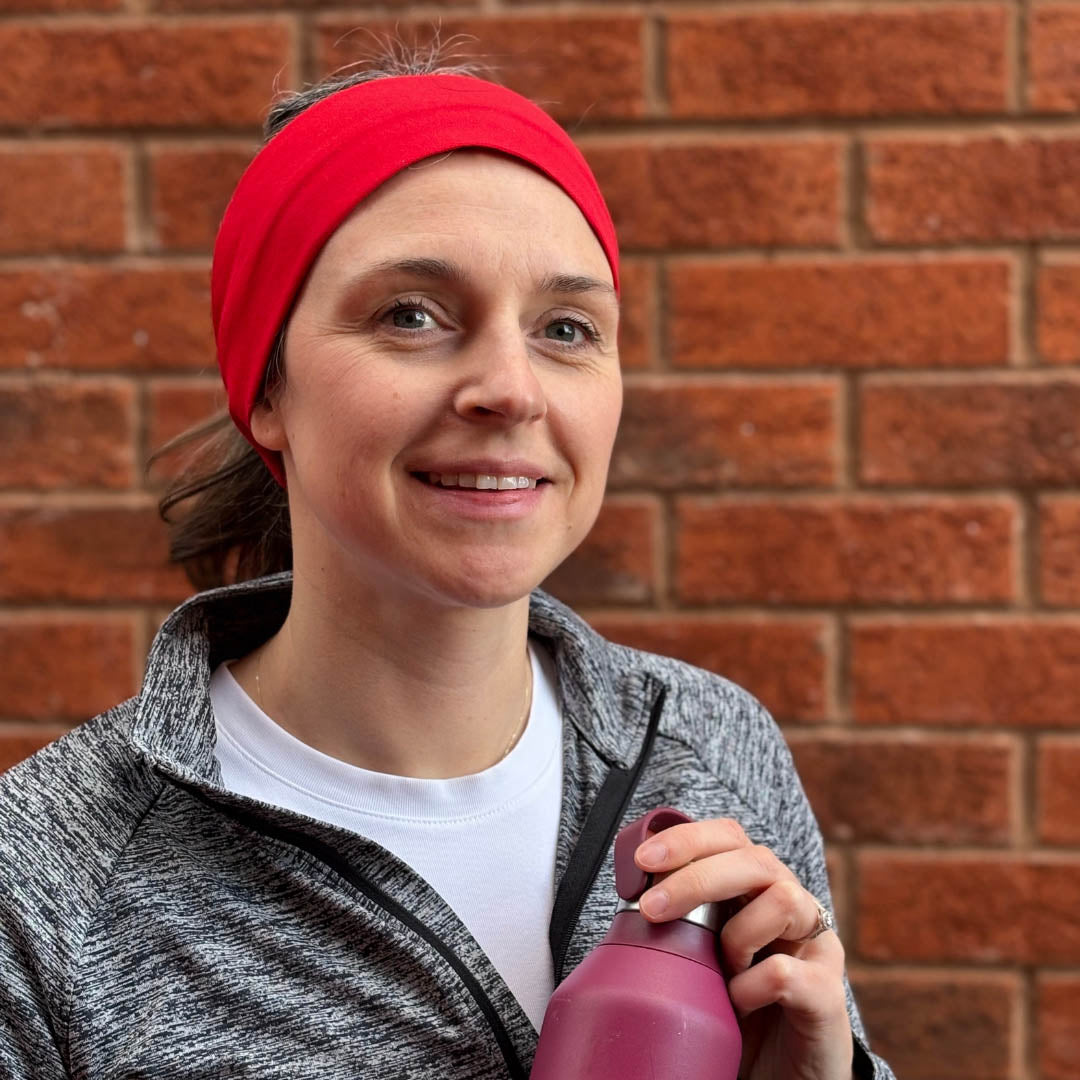 Woman in sportswear wearing poppy red organic jersey cotton headband outdoors - Good Wash Day