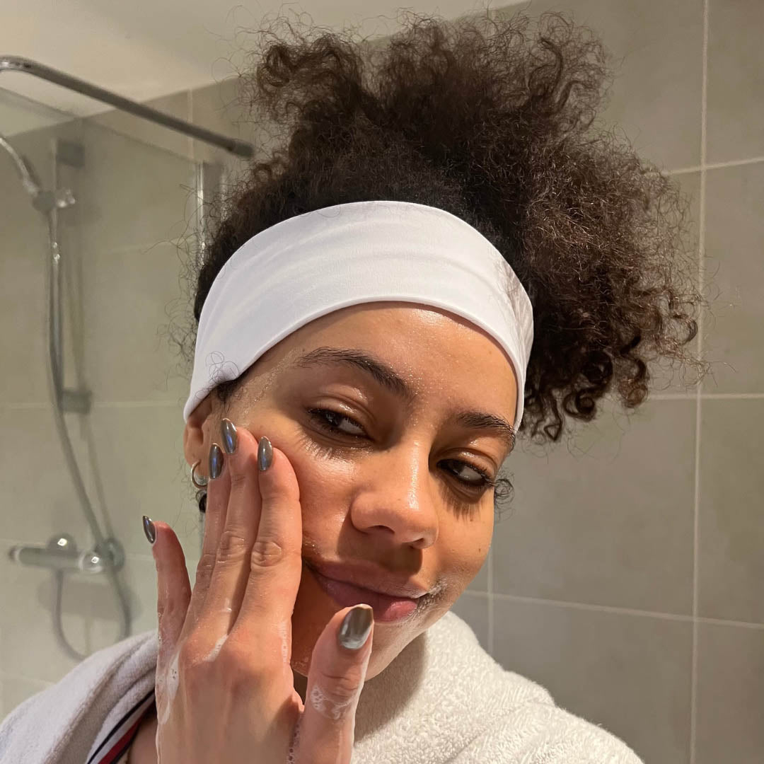 Woman with natural afro hair wearing white organic jersey cotton headband doing her skincare routine – Good Wash Day