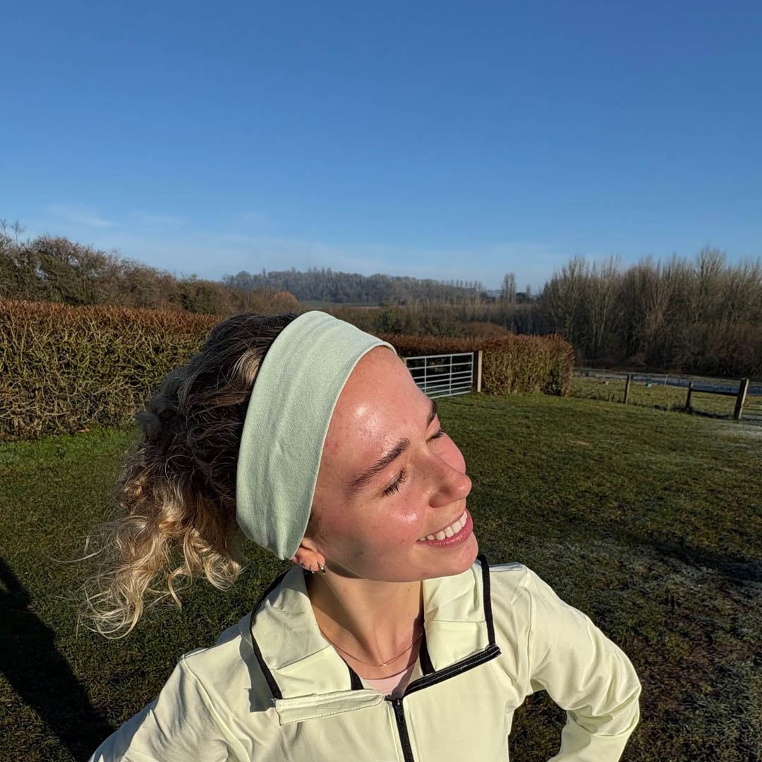 Woman outside running wearing sage green organic jersey cotton headband outdoors – Good Wash Day