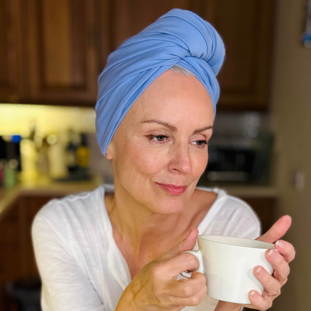 Woman in kitchen wearing cobalt blue organic jersey cotton hair towel wrap – Good Wash Day