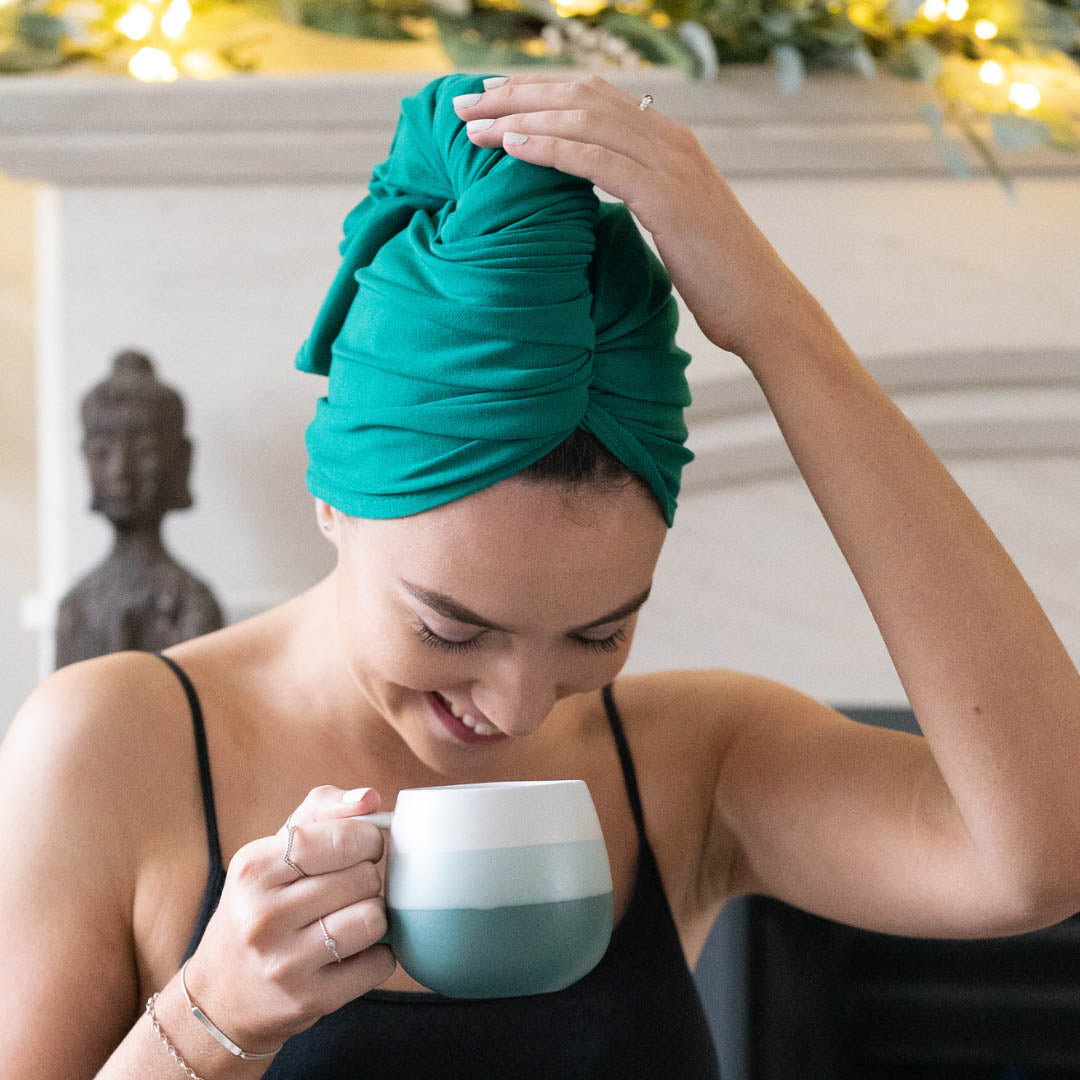 Woman adjusting holly green XL organic jersey cotton hair towel wrap – Good Wash Day