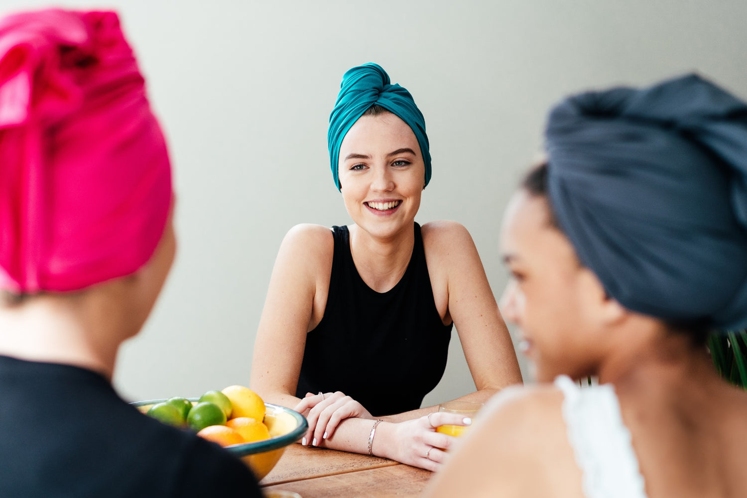 Women wearing organic jersey cotton hair towels in teal, pink and grey