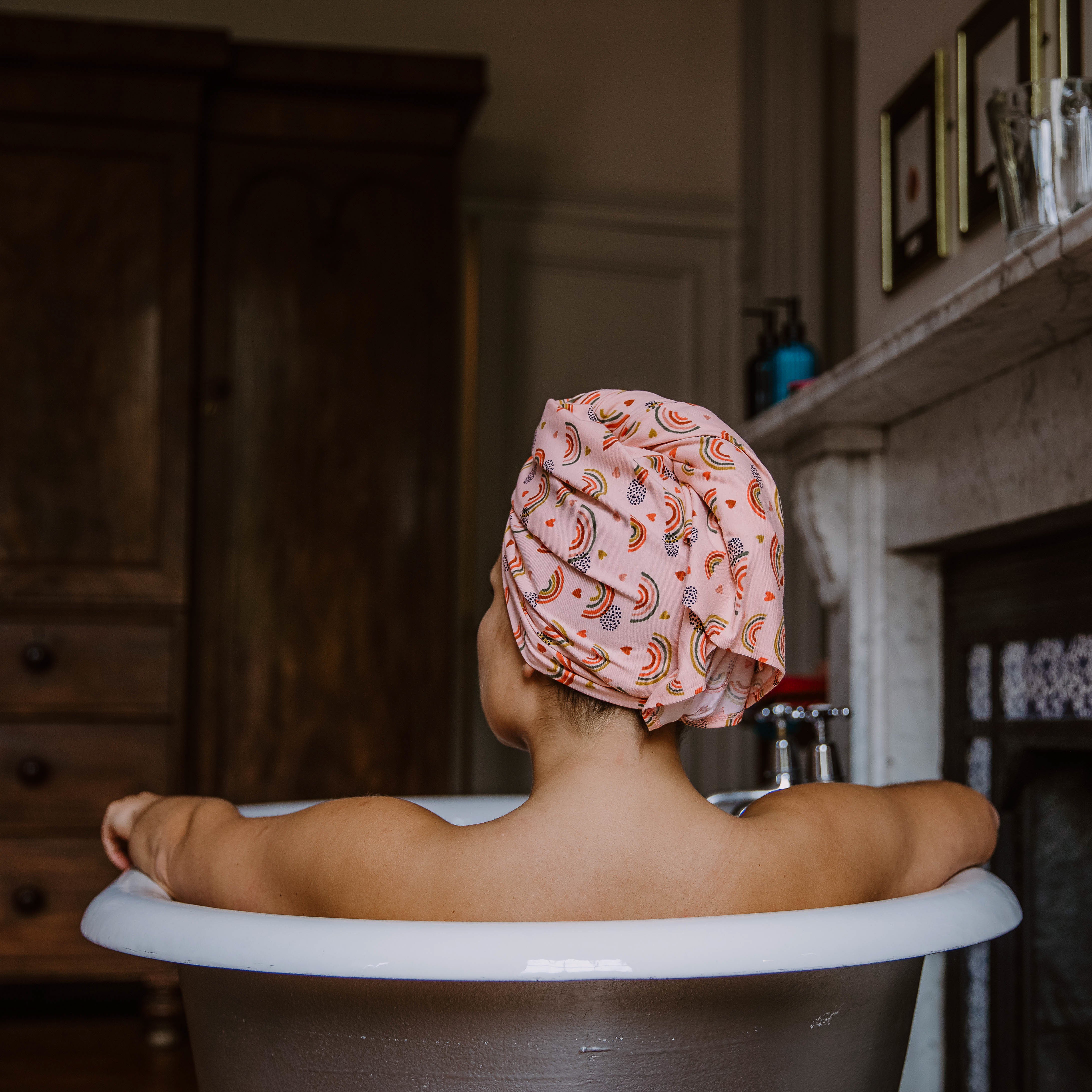 Woman wearing an organic jersey cotton hair towel in a roll-top bath
